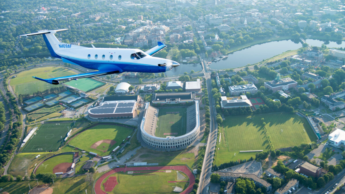 pc-12 flies over a college football stadium